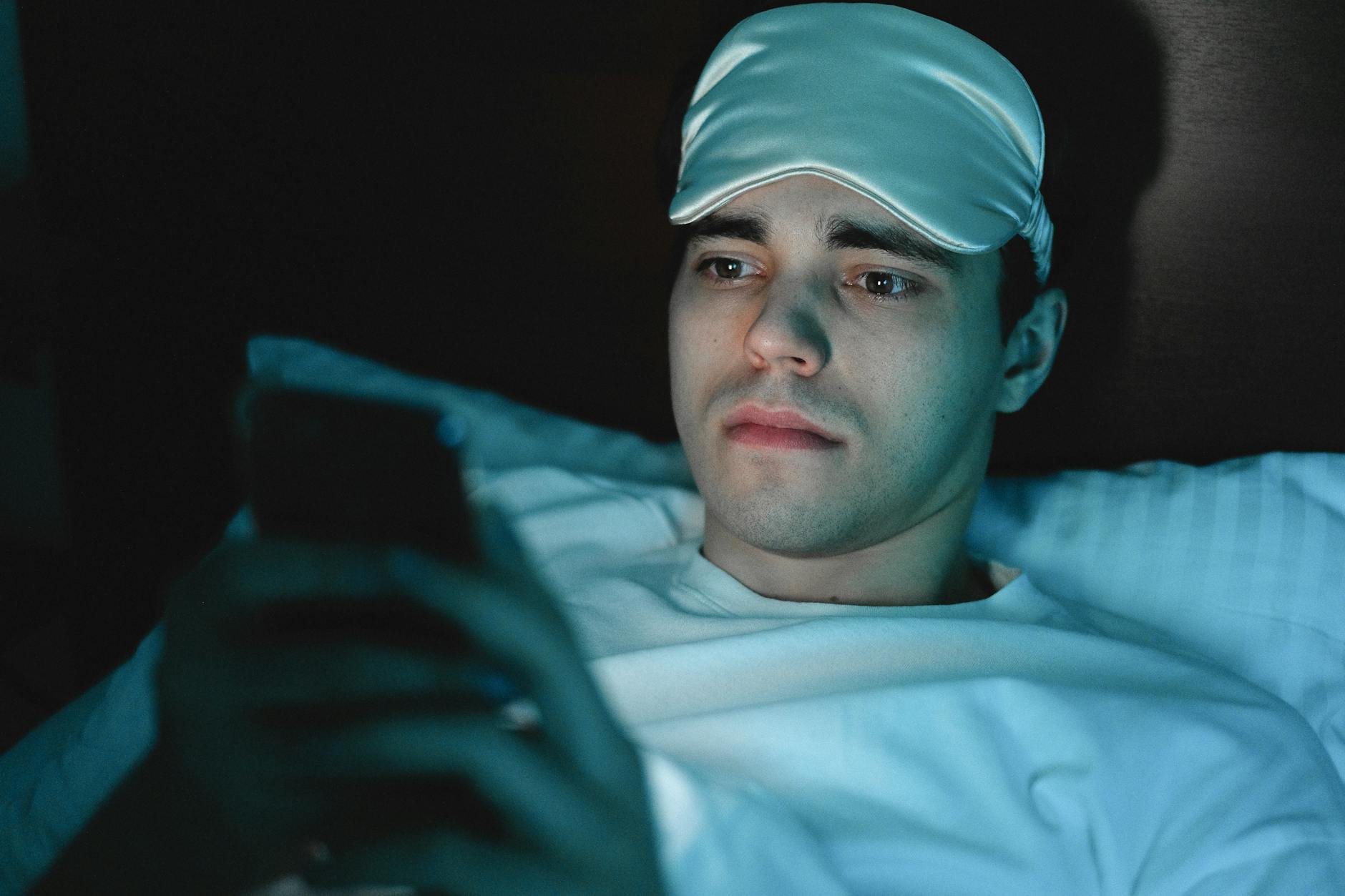 a man in white shirt with sleeping mask on his head
